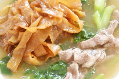 Kızarmış büyük şehriye dilimlenmiş et ve Çin lahana soslu sos tabakta. 