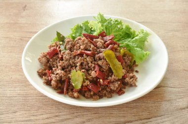 Baharatlı sığır pirzolası çift kuru biber ve tabakta marul.