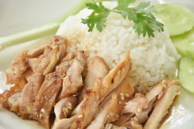 Dilimlenmiş tavuklu beyaz susamlı teriyaki Japon soslu salatalık ve taze soğanlı pilav.