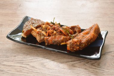 Kızarmış mango balığı, domates ve acı biberli, tabakta ekşi sos. 