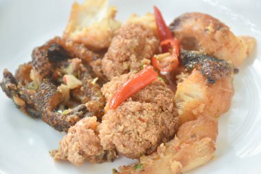 Kızarmış gümüş dikenli balık. Tabağında kırmızı biber sirkesi var. 