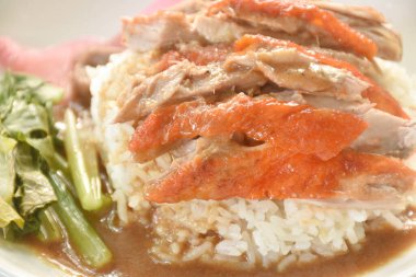 Dilimlenmiş ördek soslu pilav pembe turşulu zencefil ve haşlanmış lahana soslu tatlı soya sosu tabakta.