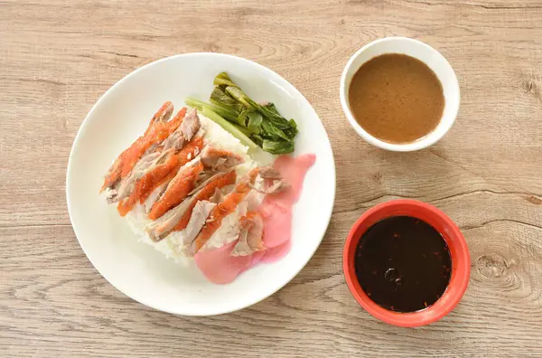 Dilimlenmiş ördek soslu pilav pembe turşulu zencefil ve haşlanmış lahana soslu tatlı soya sosu tabakta.