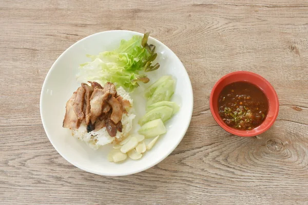 Dilimlenmiş domuz budu, salatalık ve baharatlı biber soslu pilav.