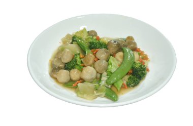 Kızarmış brokoli, yeşil bezelye ve saman mantarlı vejetaryen yemeği tabakta karıştır.  