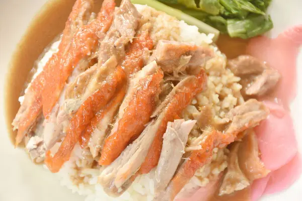 Dilimlenmiş ördek soslu pilav pembe turşulu zencefil ve haşlanmış lahana soslu tatlı soya sosu tabakta.