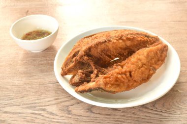 Kızarmış siyah bantlı tabakta trevally balığı baharatlı acı biber sosu.  