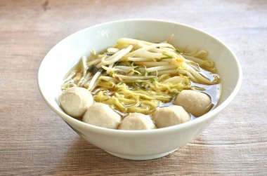 Çin usulü haşlanmış yumurtalı şehriye ile domuz köftesi ve kase üzerinde temiz çorba.