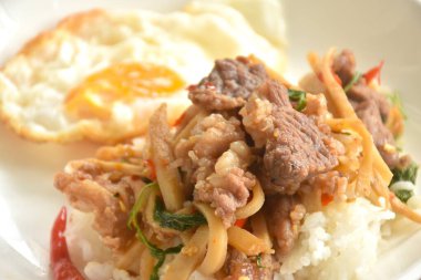 Baharatlı kızarmış bambu filizi ve pirinçli yumurta üzerine fesleğen yaprağı soslu biftek eti.  