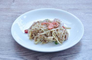 Olgunlaşmamış mango, kuru karides ve tabakta acılı Tayland salatası.