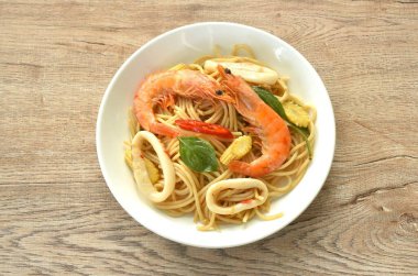 Baharatlı kızarmış spagetti, deniz ürünleri, biberli karides ve soslu fesleğen yaprağı. 