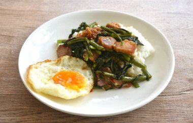 Kızarmış sabah zaferi, kızarmış domuz eti ve tabakta pilav üstü yumurta.