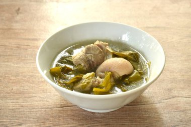 Kaynamış domuz budu ve klozetin üzerinde kova yaprağı çorbası.