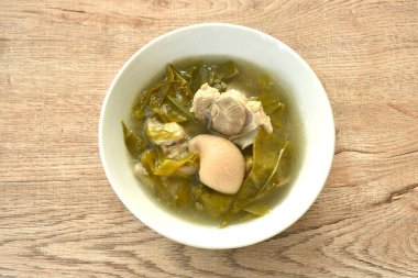 Kaynamış domuz budu ve klozetin üzerinde kova yaprağı çorbası.