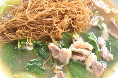 Dilimlenmiş etli makarna ve Çin lahanası soslu sos. 