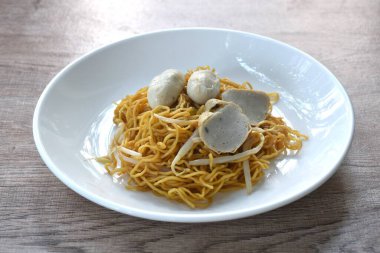 Çin usulü kuru erişte ve fasulye filizi soslu domuz köftesi ve tabakta dilimlenmiş balık.