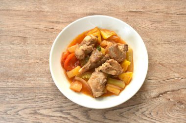 Kızarmış sebze, pirzola, domuz kemiği, tatlı ve ekşi sos, beyaz tabakta. 