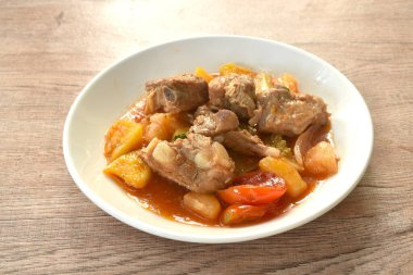 Kızarmış sebze, pirzola, domuz kemiği, tatlı ve ekşi sos, beyaz tabakta. 