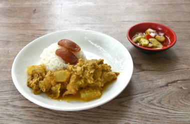 Baharatlı karpuz ve domuz eti çorbası. Tabakta birkaç pilav, tatlı biber sosu. 