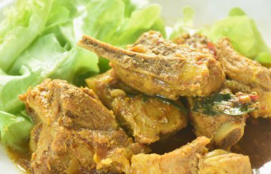 Baharatlı domuz kemiği ve körili taze yeşil meşe salatası.