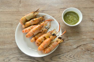 Izgara nehir karidesi tabağa yerleştirilmiş baharatlı Tayland deniz ürünleri sosu. 