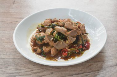 Baharatlı biberli kızarmış tavuk eti ve tabağında fesleğen yaprağı olan çift ciğer.