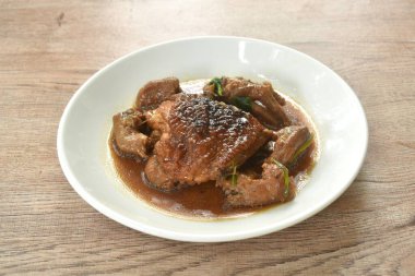 Buharda pişirilmiş tavuk budu ve tabakta sarımsaklı karabiber soslu ayak.