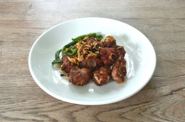 Kızarmış gevrek mayalanan domuz kemiği, çıtır sarımsak ve kırmızı biber tabağı. 