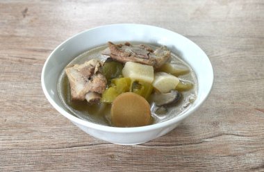 Haşlanmış turp ve acı salatalık ve kase üzerinde domuz kemiği çorbası. 