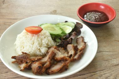 Pirinç soslu ızgara mayalanan domuz eti iki salatalık ve baharatlı barbekü sosunu tabakta yiyin. 