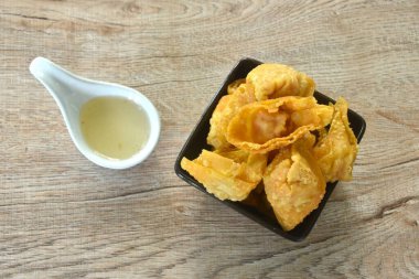 Kızarmış hamur hamuru doldurulmuş domuz pirzolası ve karides tatlı acı biber sosunu fincana bandırıyor.