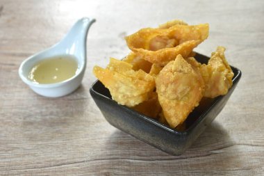 Kızarmış hamur hamuru doldurulmuş domuz pirzolası ve karides tatlı acı biber sosunu fincana bandırıyor.