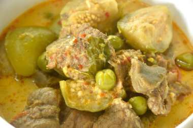 Hindistan cevizi sütüyle patlıcanlı haşlanmış biftek, kase üzerinde kırmızı köri çorbası. 