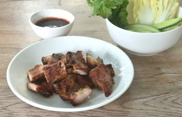 stock image gilled slice pork bone on plate with vegetable dipping spicy chili tamarind sauce