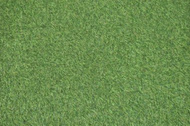 Futbol sahası dokusu ve arkaplanı üzerindeki yeşil yapay çimleri kapat