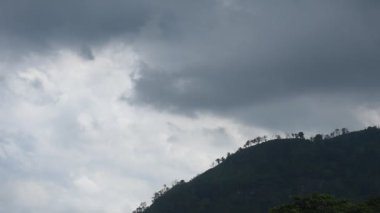 Tayland 'daki Sai Thong su deposunda yağmur bulutu ve sisle kaplı dağ manzarası.