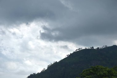 Tayland 'daki Sai Thong su deposunda yağmur bulutu ve sisle kaplı dağ manzarası.