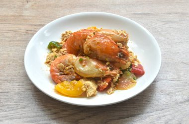 Kızarmış nehir karidesini yumurta ve soya soslu dolma biberle karıştır.