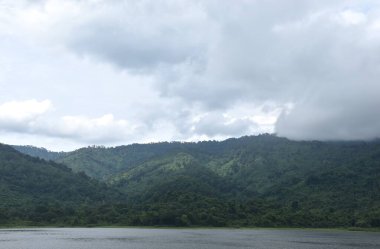 Tayland 'daki Sai Thong su deposunda yağmur bulutu ve sisle kaplı dağ manzarası.