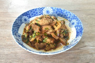 Pirzola ve acılı Tayland salatası dilimlenmiş domuz eti. Tabakta baharatlı ve ekşi.