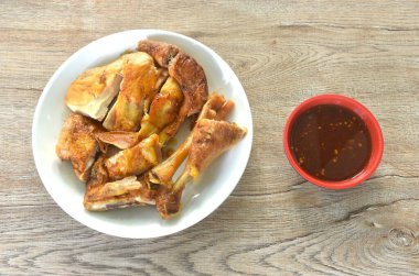 Kızarmış tavuk eti kanadı ve bacağı baharatlı sosa batırılmış. 