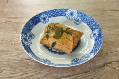 Hint cevizi sütüyle buharda pişirilmiş palyaço bıçağı ve tabakta limon yaprağı. 