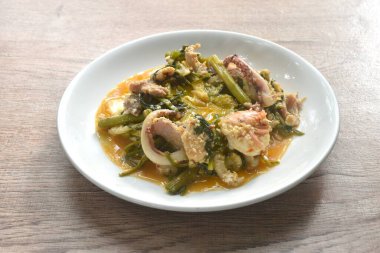 Tavuk ve domuz etli kızarmış deniz ürünleri tabakta sukiyaki soslu yumurta sarısı yiyen sebzeli çift.