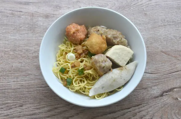 stock image dry Chinese yellow egg noodles topping steamed Hakka meatball made from chop pork stuffing fried tofu on bowl