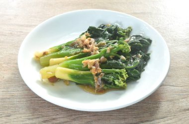 Kailaan usulü kızarmış lahana soslu istiridye sosu ve tabakta sarımsak.