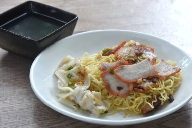 Kuru Çin yumurtası sarısı erişte. Kırmızı ızgara domuz eti ve tabakta taze çorba.