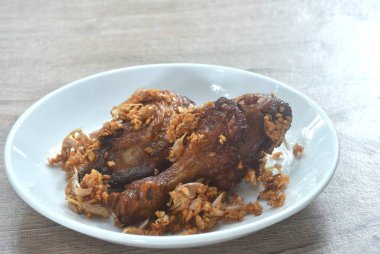 Bol yağda kızartılmış tavuk ve biber soslu kızarmış sarımsak tabakta.