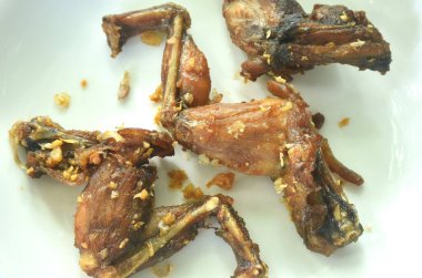 Tuzlu, bol yağda kızartılmış dağ kurbağası bacağı ve çıtır sarımsaklı Tayland yemeği.