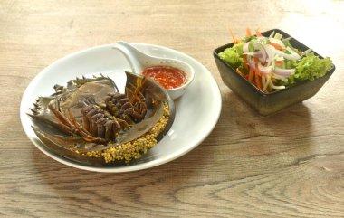 spicy and sour sea horseshoe crab egg wiith slice vegetable salad Thai food on plate clipart