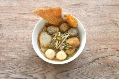 Domuz pirzolasından yapılmış haşlanmış Hakka köftesi fasulye filizi ile kızarmış tofu ve baharatlı Tom çorbası içinde çıtır çıtır balık köftesi.